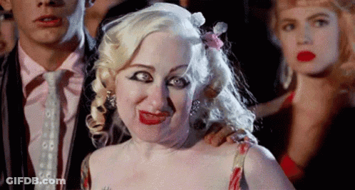 Woman Making Funny Face Next To Man In Suit GIF
