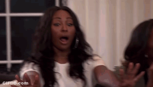 Woman Making Funny Face On Couch With Hands Outstretched GIF