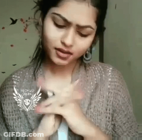 Woman Making Funny Face With Hands In Sweater And Earrings GIF