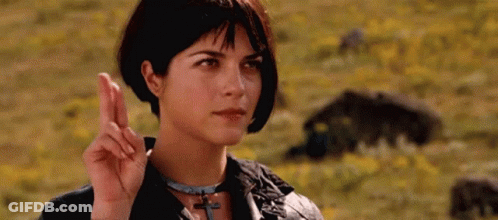 Woman Making Peace Sign In Flower Field GIF