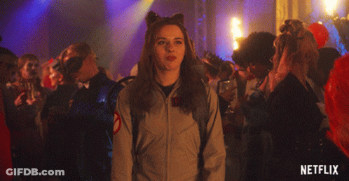Woman Making Peace Sign In Front Of Crowd With Netflix Logo GIF