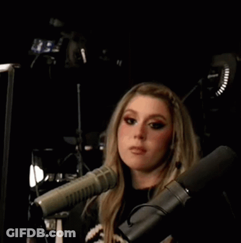 Woman Making Peace Sign In Front Of Microphone GIF
