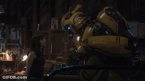 Woman Next To Yellow Robot In Dark Room GIF