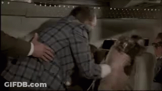 Woman On Airplane Talking To Man In Black Hood GIF