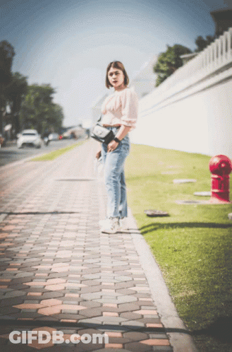 Woman On Brick Sidewalk Near Red Fire Hydrant GIF