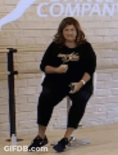 Woman On Chair By Brick Wall With Company GIF