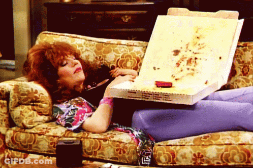 Woman On Couch Holding Pizza Box Saying LS GIF