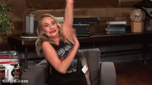 Woman On Couch With Arm Up Wearing Led Girl Shirt GIF