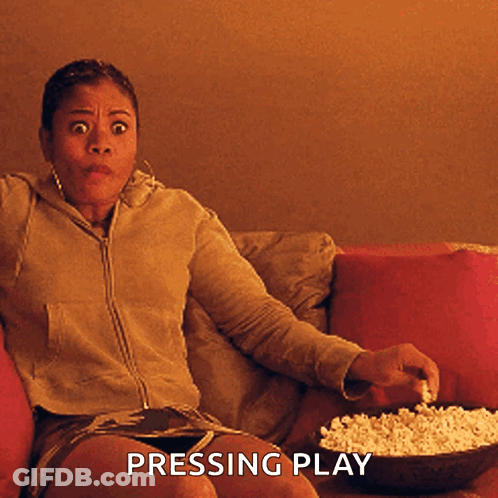 Woman On Couch With Popcorn Pressing Play GIF