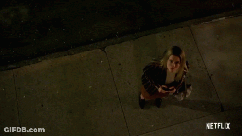 Woman On Sidewalk With Netflix Logo GIF
