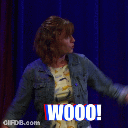 Woman On Stage With Arms Up Saying Fireworks GIF