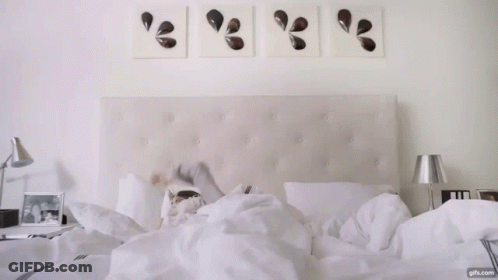 Woman On White Sheets With Nightstand Lamp GIF