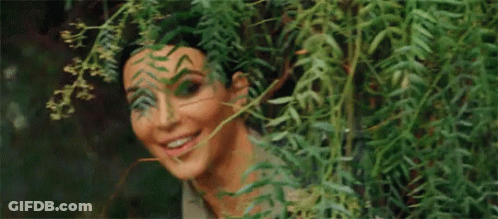 Woman Peeking From Behind Tree GIF