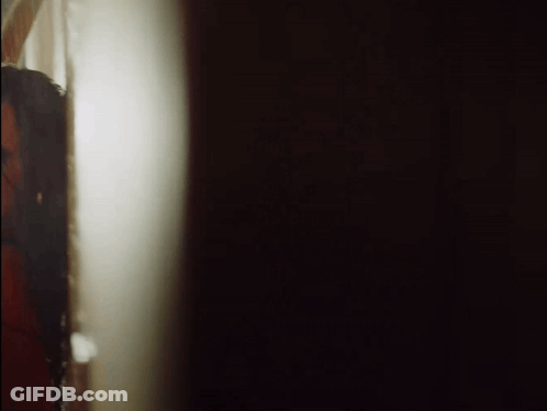 Woman Peeking From Behind Wall GIF