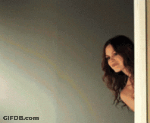 Woman Peeking Out Doorway GIF