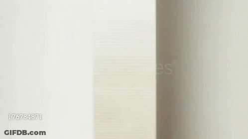 Woman Peeking Out Of Wall Smiling GIF