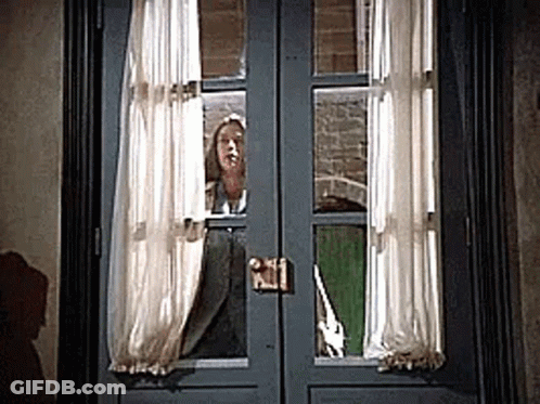 Woman Peeking Out Window With Curtains GIF