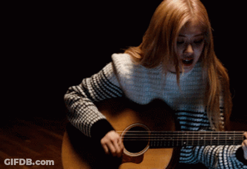 Woman Playing Acoustic Guitar In Dark Room GIF