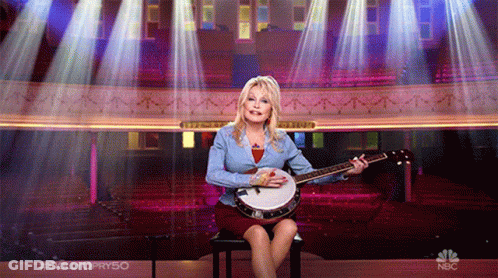 Woman Playing Banjo On Chair With NBC Logo GIF