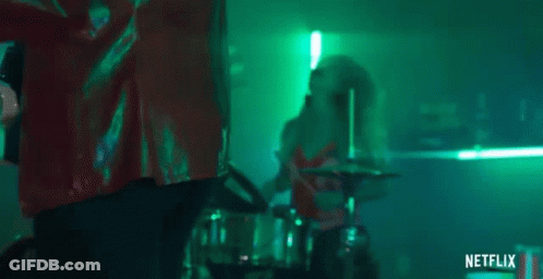 Woman Playing Drums In Dark Room With Green Lights GIF