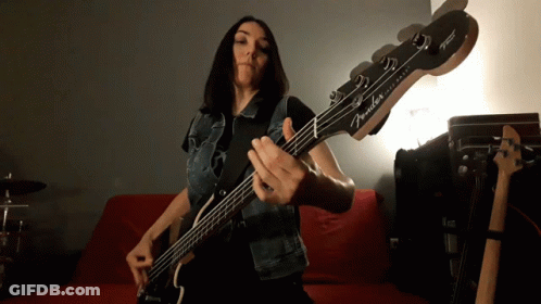 Woman Playing Fender Bass Guitar On Red Couch GIF