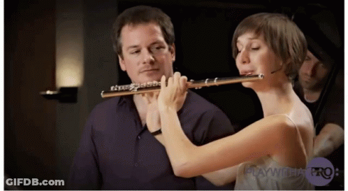 Woman Playing Flute In Front Of Man Playing Cello GIF