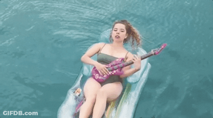 Woman Playing Guitar In Center Of The Pool GIF