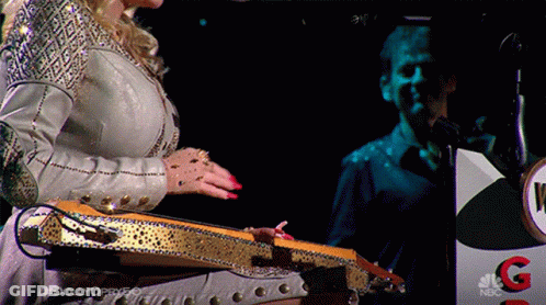 Woman Playing Guitar In Front Of NBC Podium GIF