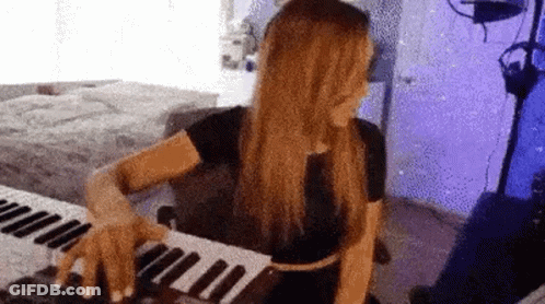 Woman Playing Keyboard In Purple Room GIF