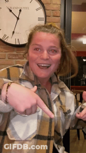 Woman Pointing At Clock Saying Grand Hotel GIF