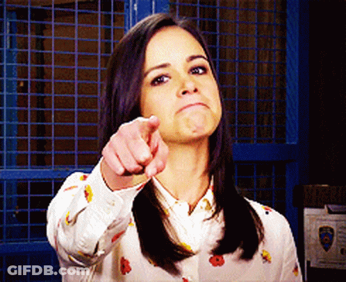 Woman Pointing Finger At Camera With Blue Fence GIF