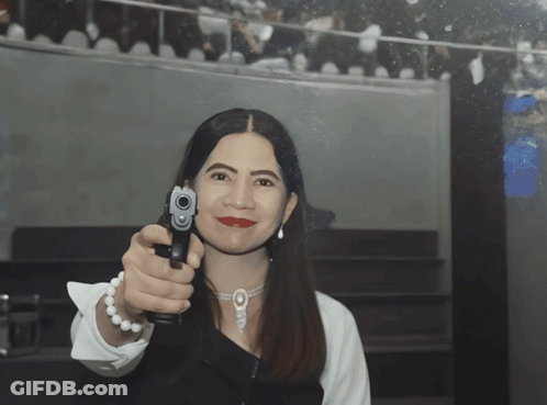 Woman Pointing Gun Wearing Pearls GIF