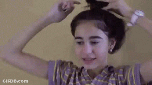 Woman Putting Hair In A Bun While Wearing Watch GIF