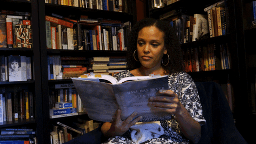 Woman Reading Book Inside Library GIF