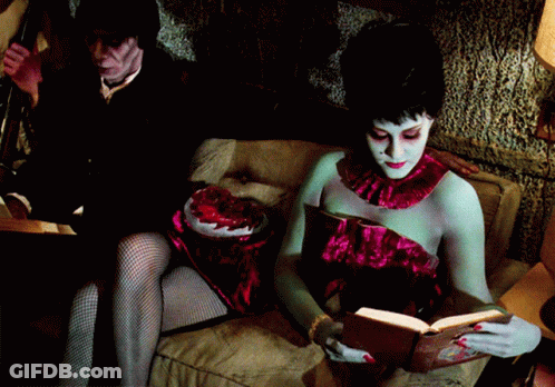 Woman Reading Book Man Holding Heart GIF