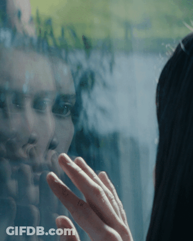 Woman Reflected In Window Touching Glass GIF