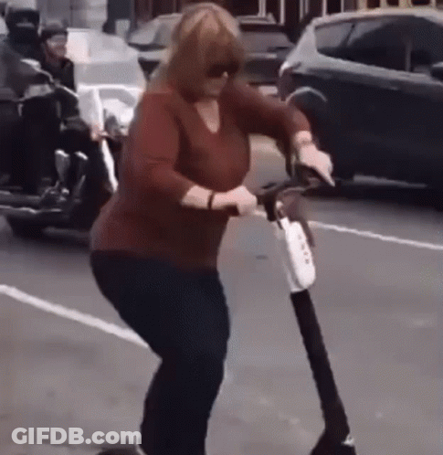 Woman Riding Scooter On Street GIF