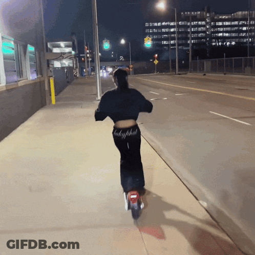 Woman Riding Scooter With Baby Phat Pants GIF