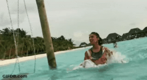 Woman Riding Swing In Pool GIF