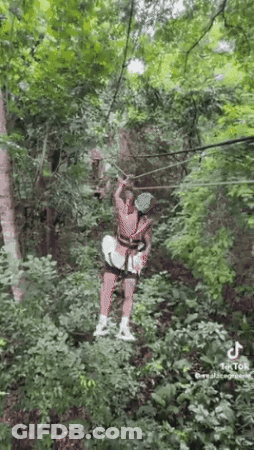 Woman Riding Zip Line In Woods GIF