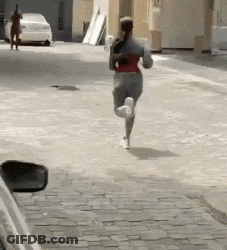 Woman Running Down Cobblestone Street With Car GIF