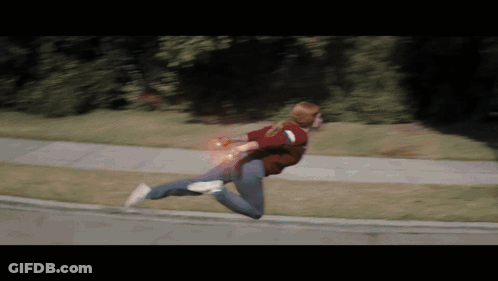 Woman Running Down Sidewalk With Red Light From Hand GIF