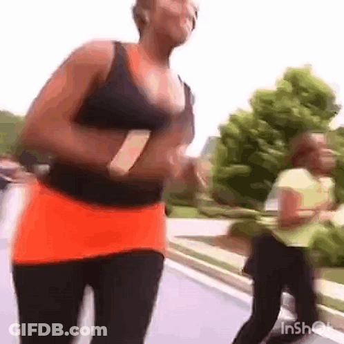 Woman Running Down Street In Black Tank Top And Orange Skirt GIF