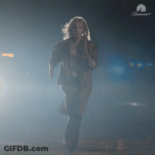 Woman Running In Dark Room With Paramount Logo GIF