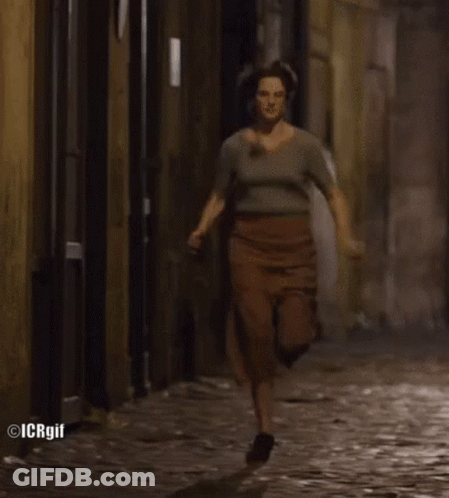 Woman Running On Cobblestone Street GIF