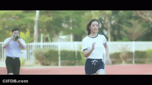 Woman Running On Track Man Taking Picture GIF