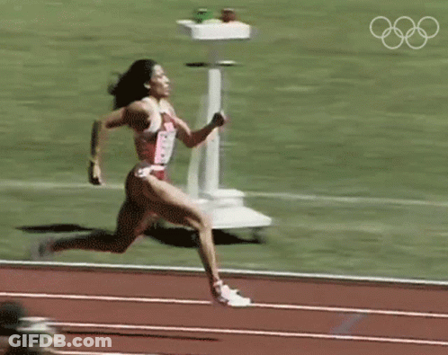 Woman Running On Track With Olympic Rings GIF