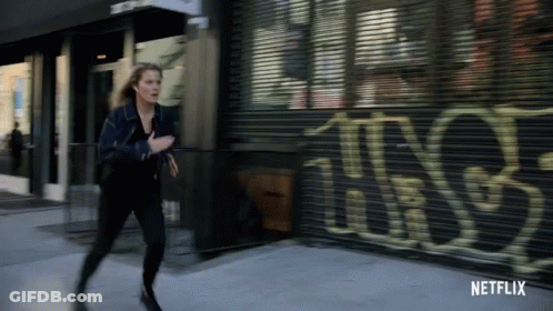 Woman Running Past Netflix Building GIF