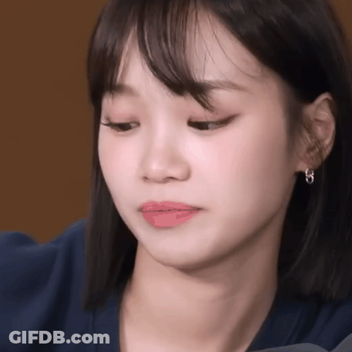 Woman's Face Close Up With Blue Shirt And Earrings GIF