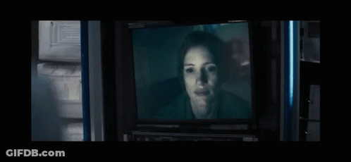 Woman's Face On TV In Dark Room GIF